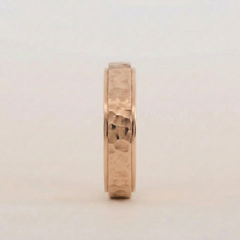 Gold ring with a textured band on a light gray background