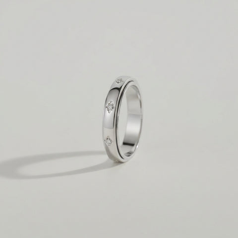 Silver ring with embedded diamonds on a light gray background