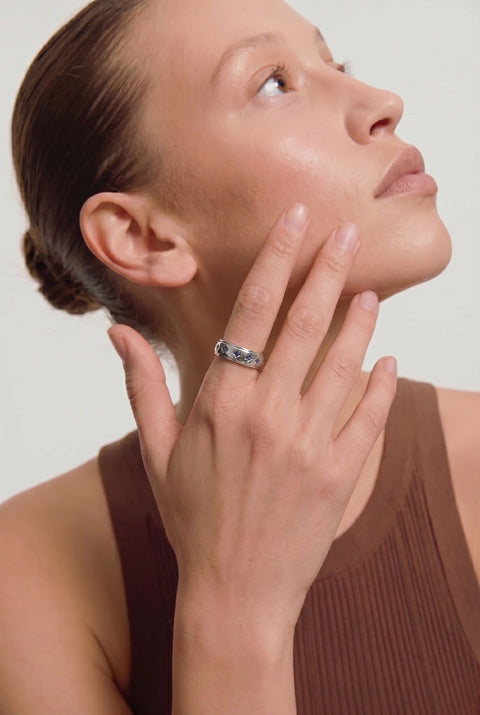 Woman wearing a ring on her finger against a neutral background