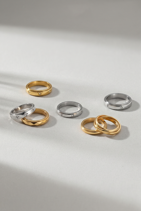 Set of gold and silver rings on a light gray background